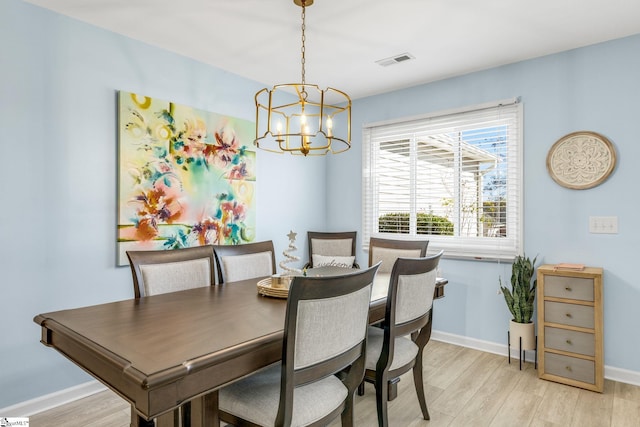 dining area featuring a notable chandelier and light wood-type flooring