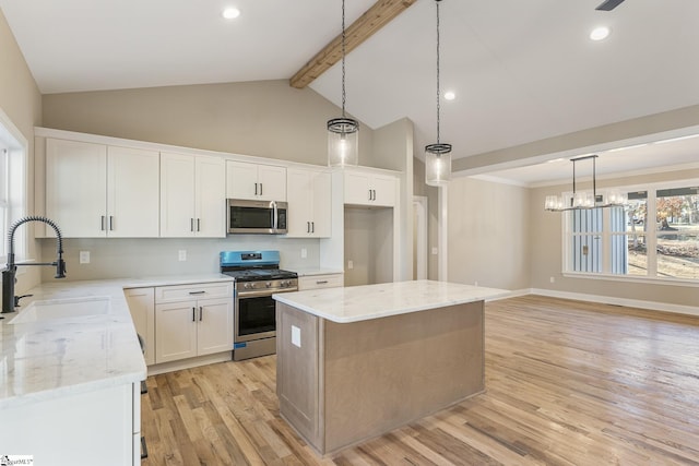 kitchen with a center island, decorative light fixtures, stainless steel appliances, white cabinetry, and a sink