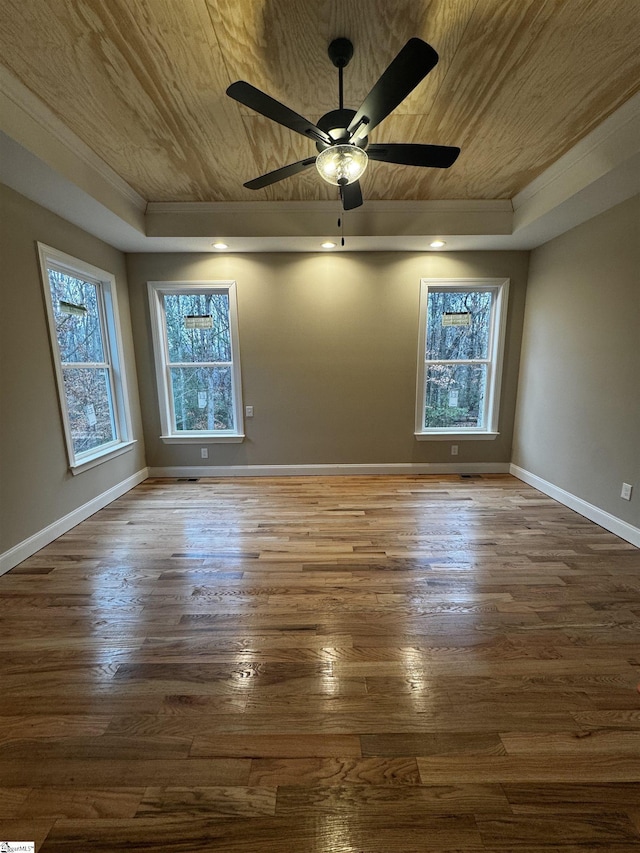 spare room with dark wood-style floors, a tray ceiling, and wooden ceiling