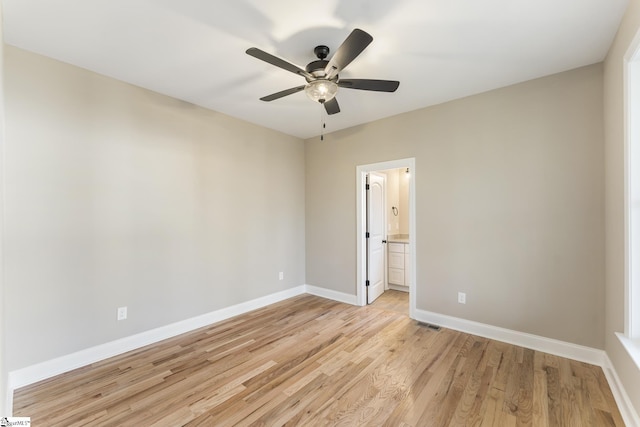 unfurnished room with ceiling fan, light wood-type flooring, visible vents, and baseboards