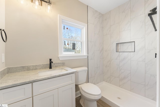 bathroom featuring a stall shower, vanity, and toilet