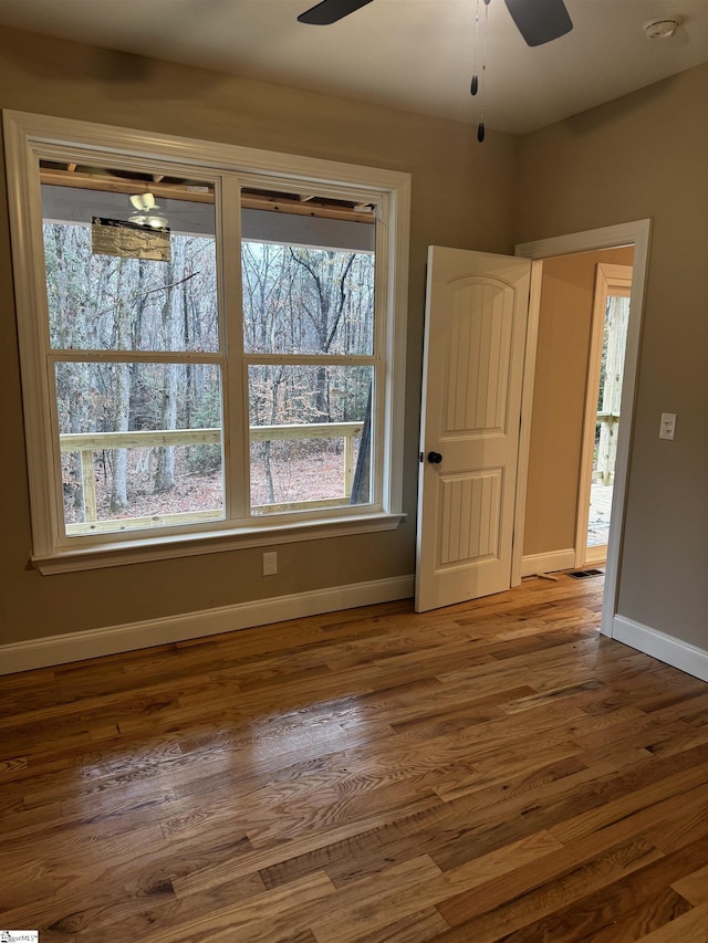 interior space with ceiling fan, baseboards, and wood finished floors