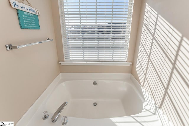 bathroom featuring a bath and a wealth of natural light