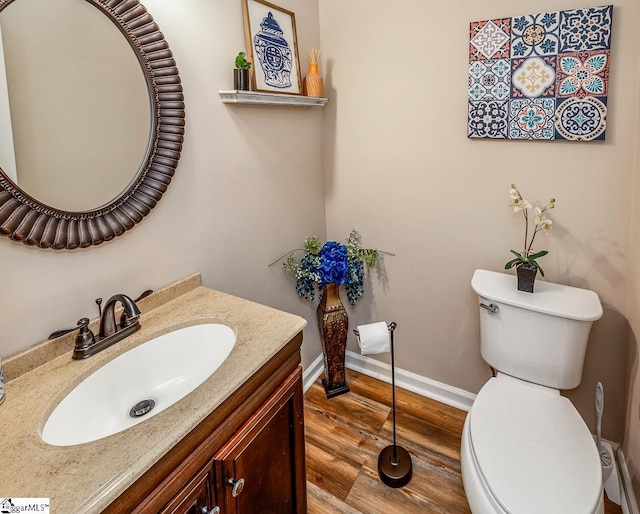 bathroom with vanity, wood-type flooring, and toilet