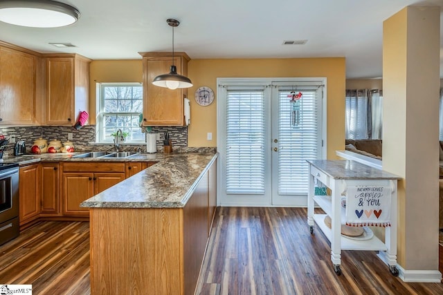 kitchen featuring decorative backsplash, decorative light fixtures, dark hardwood / wood-style floors, and sink