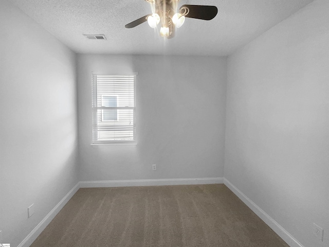 carpeted empty room with ceiling fan and a textured ceiling