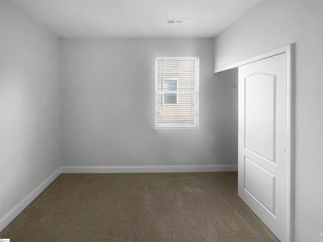 unfurnished room featuring carpet floors and a textured ceiling