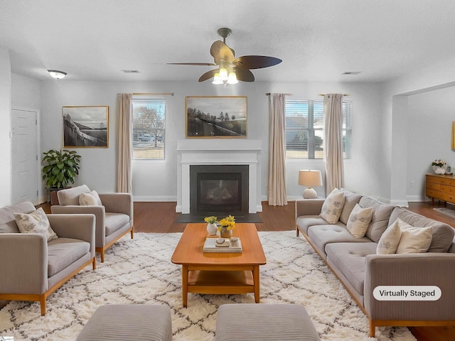 living room featuring plenty of natural light, light hardwood / wood-style floors, a textured ceiling, and ceiling fan