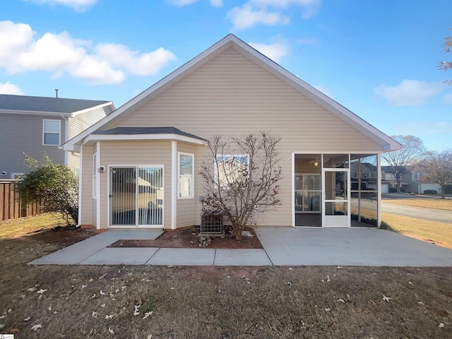 back of property with a patio area and a sunroom