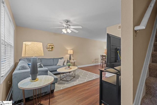 living room featuring ceiling fan and dark wood-type flooring