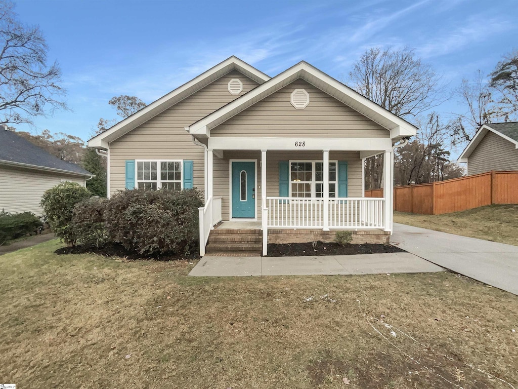 view of front of property with covered porch and a front yard