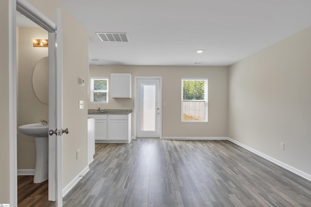 unfurnished living room featuring hardwood / wood-style floors and sink