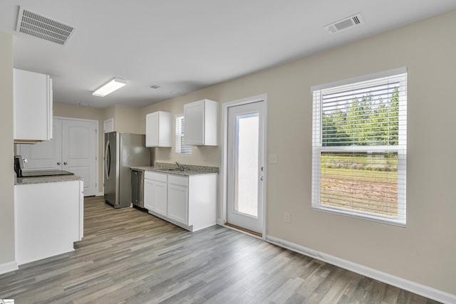 kitchen with white cabinetry, sink, light hardwood / wood-style flooring, and appliances with stainless steel finishes