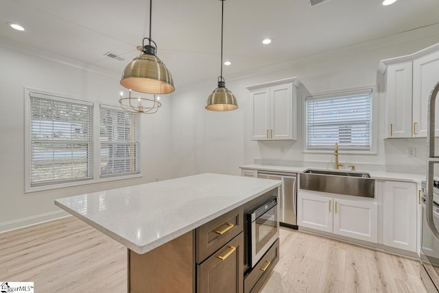 kitchen with white cabinets, pendant lighting, a center island, and a wealth of natural light