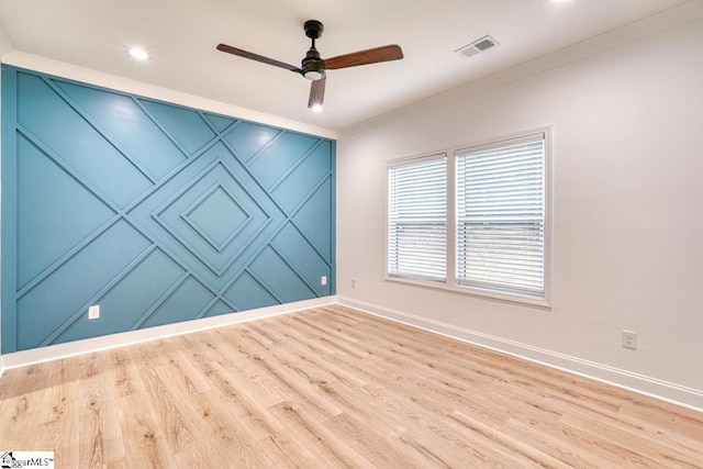 spare room featuring light wood-type flooring, ceiling fan, and crown molding