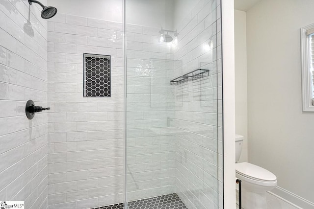 bathroom with tiled shower and toilet