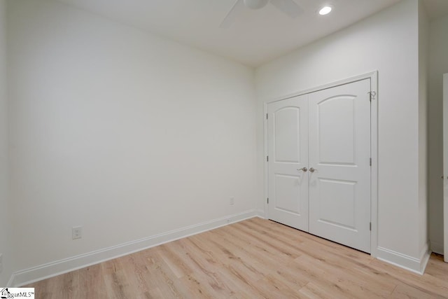 unfurnished bedroom featuring light wood-type flooring, a closet, and ceiling fan