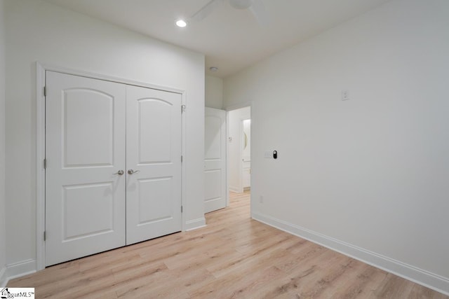 unfurnished bedroom featuring a closet, light hardwood / wood-style flooring, and ceiling fan