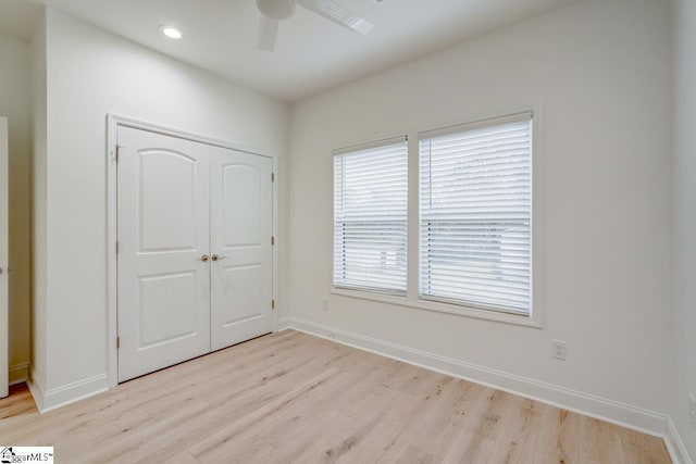 unfurnished bedroom featuring light hardwood / wood-style flooring, a closet, and ceiling fan