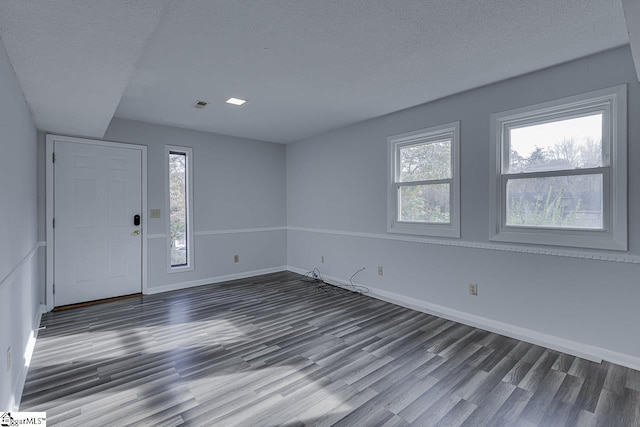 foyer with a textured ceiling and dark hardwood / wood-style floors