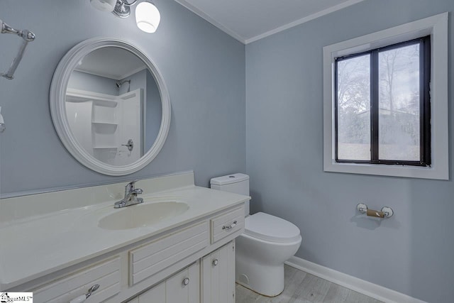 bathroom with crown molding, hardwood / wood-style floors, vanity, and toilet