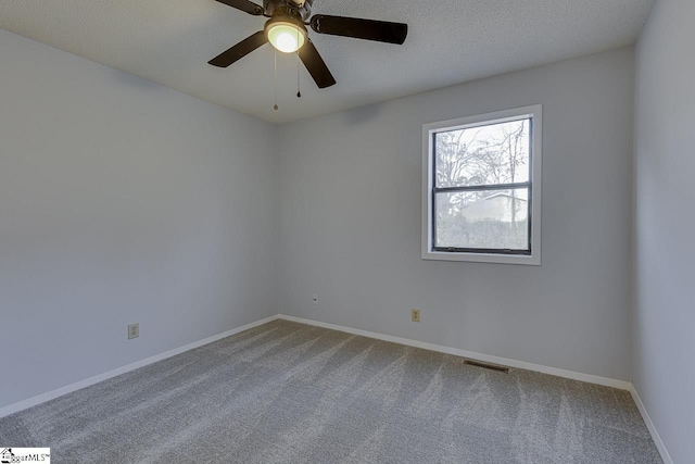 carpeted empty room with ceiling fan and a textured ceiling