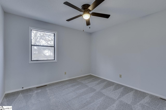 spare room featuring carpet, a textured ceiling, and ceiling fan