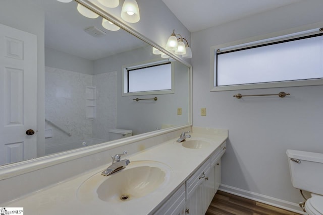 full bathroom with wood-type flooring, vanity, toilet, and a healthy amount of sunlight