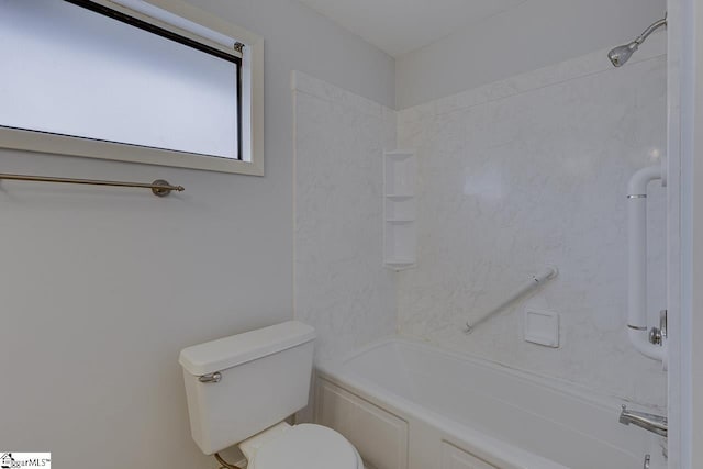 bathroom with tiled shower / bath combo and toilet