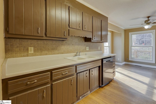 kitchen featuring dishwasher, backsplash, sink, light hardwood / wood-style flooring, and ornamental molding