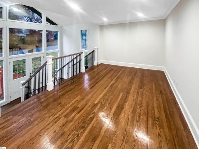 spare room with hardwood / wood-style floors and lofted ceiling