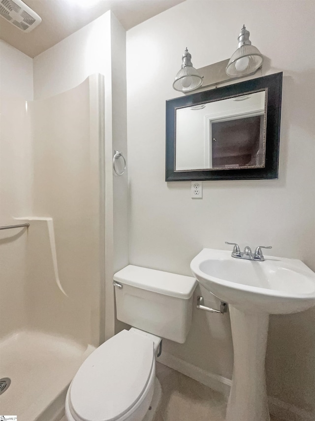 bathroom featuring sink, toilet, and walk in shower