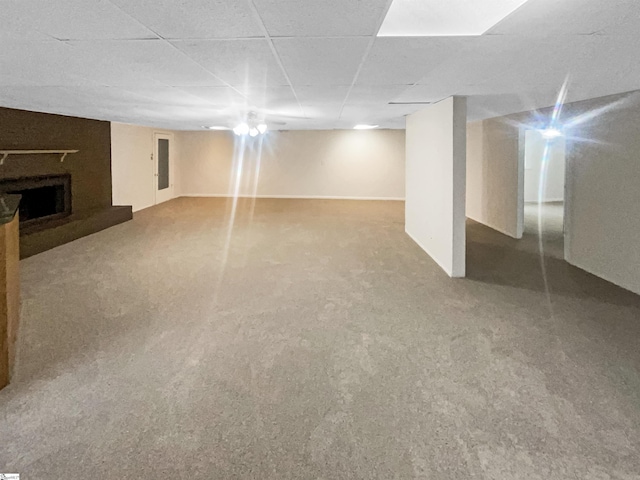 basement featuring carpet and a paneled ceiling