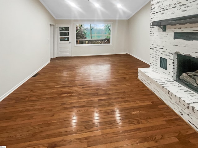 unfurnished living room featuring a fireplace, dark hardwood / wood-style floors, and ornamental molding