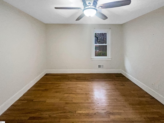 spare room featuring ceiling fan and dark wood-type flooring