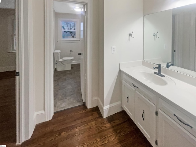 bathroom featuring wood-type flooring, vanity, and toilet