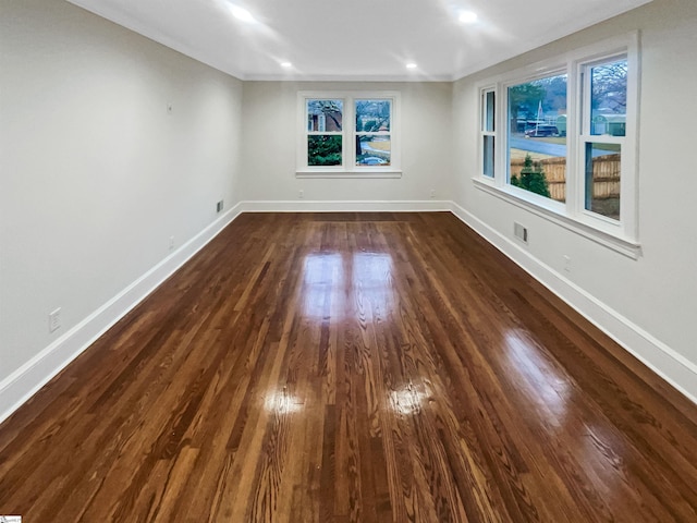 unfurnished room featuring crown molding and dark wood-type flooring