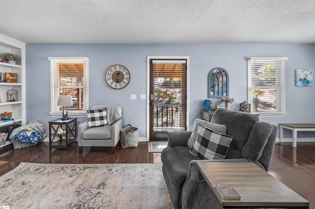 living room featuring dark hardwood / wood-style flooring, a healthy amount of sunlight, and a textured ceiling