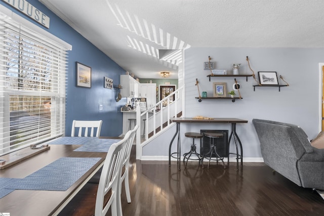 dining area with dark hardwood / wood-style floors and a textured ceiling