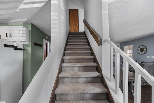 staircase featuring hardwood / wood-style flooring and a textured ceiling