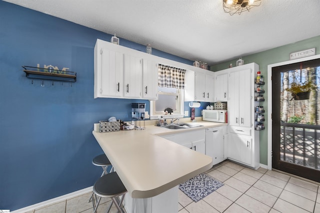 kitchen featuring a textured ceiling, white cabinetry, and white appliances