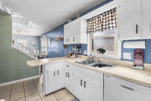 kitchen with sink, light tile patterned floors, white dishwasher, a textured ceiling, and white cabinets