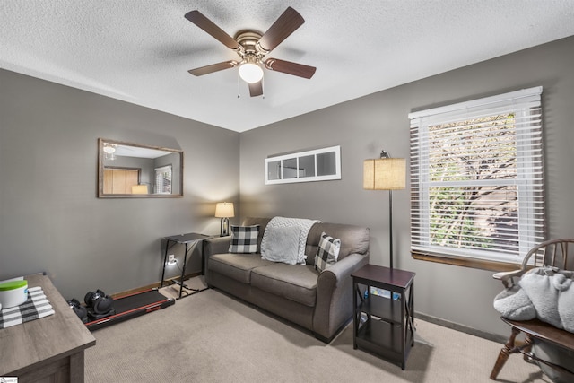 living room with ceiling fan, light colored carpet, and a textured ceiling