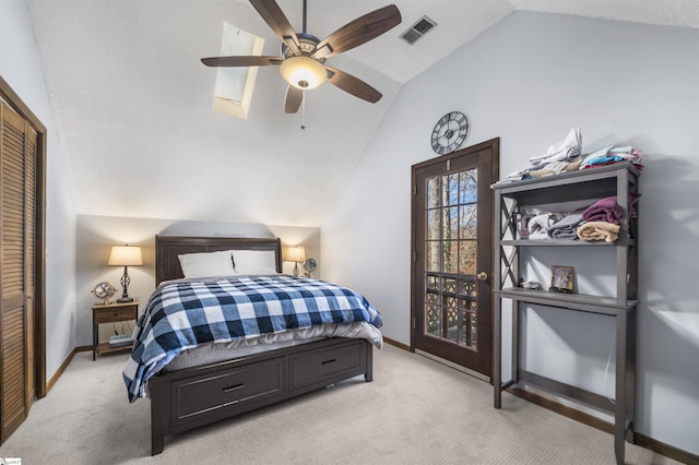 bedroom with ceiling fan, a closet, light carpet, and lofted ceiling