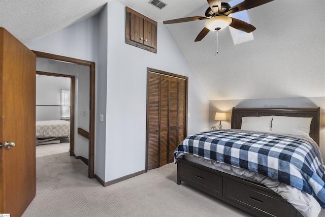 carpeted bedroom featuring ceiling fan, vaulted ceiling, a textured ceiling, and a closet