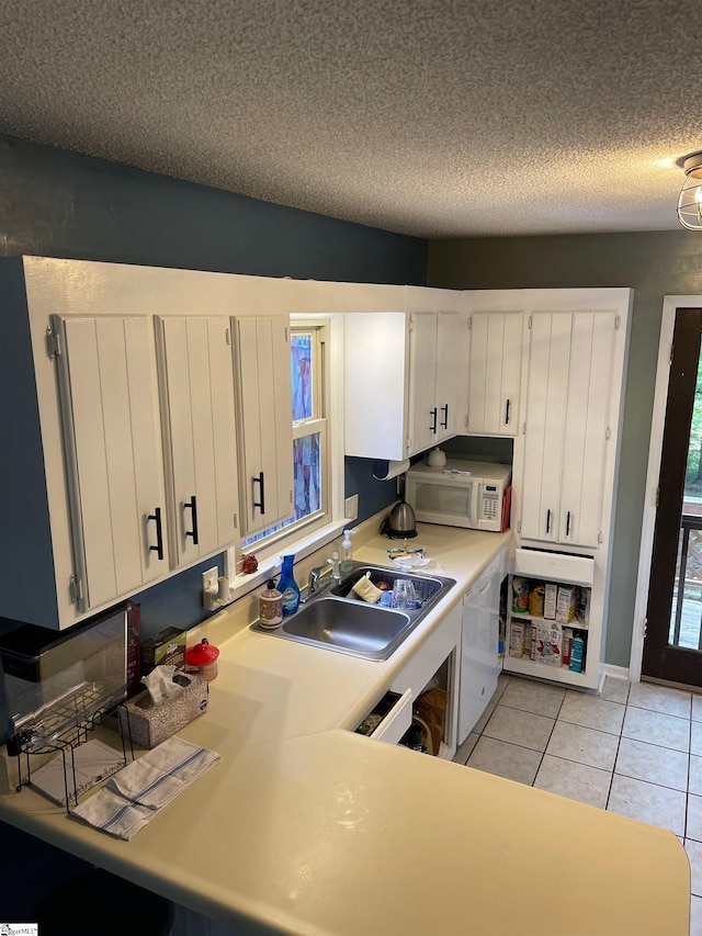 kitchen with a textured ceiling, white appliances, white cabinetry, and sink