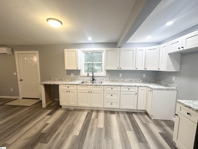 kitchen featuring white cabinetry, sink, and light hardwood / wood-style flooring