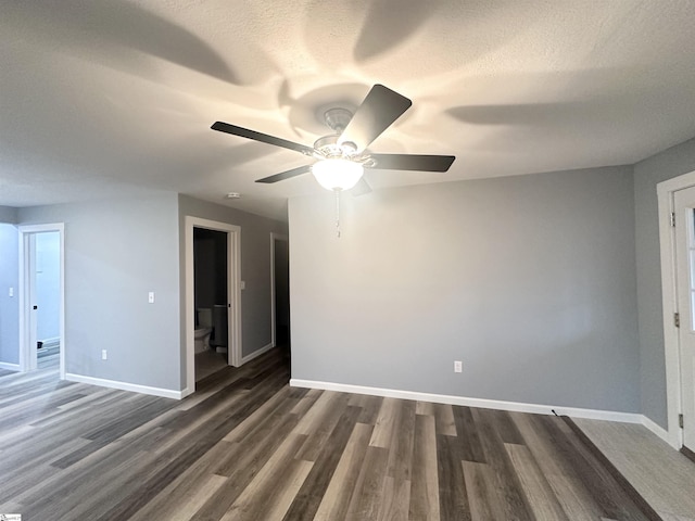 unfurnished room with a textured ceiling, ceiling fan, and dark wood-type flooring