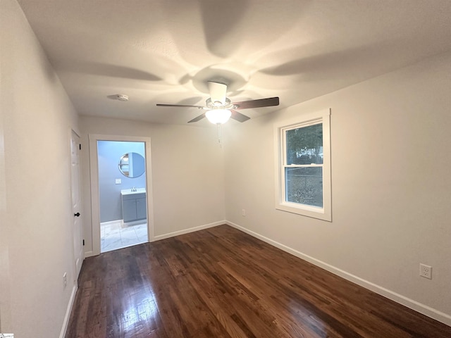 spare room featuring ceiling fan, dark hardwood / wood-style flooring, and sink