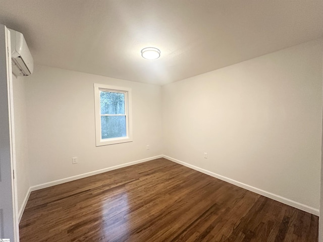 empty room with dark hardwood / wood-style floors and a wall mounted AC